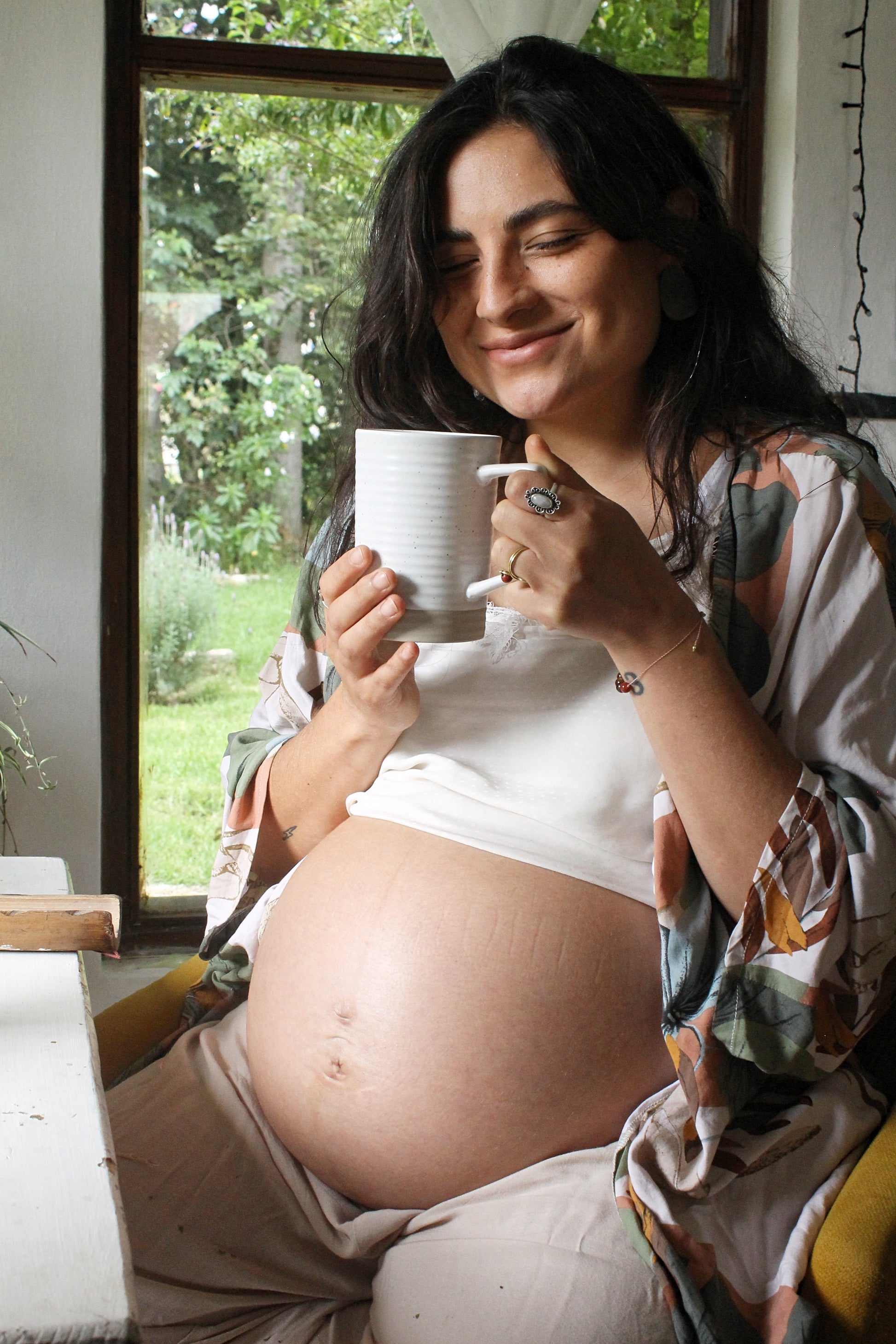 pregnant woman smiling drinking tea